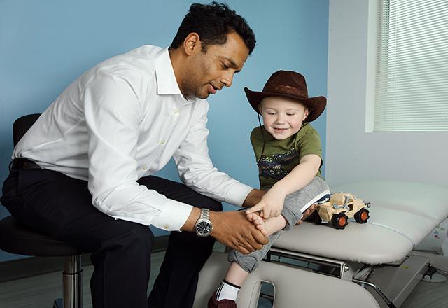 doctor checks on a child wearing a cowboy hat
